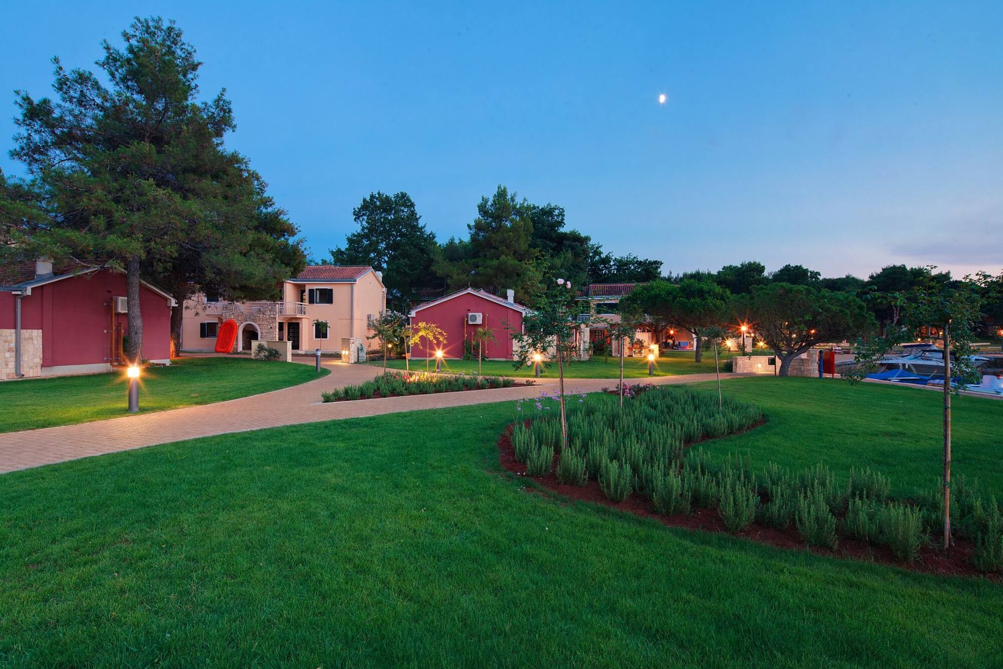 a lawn with trees and houses in the background