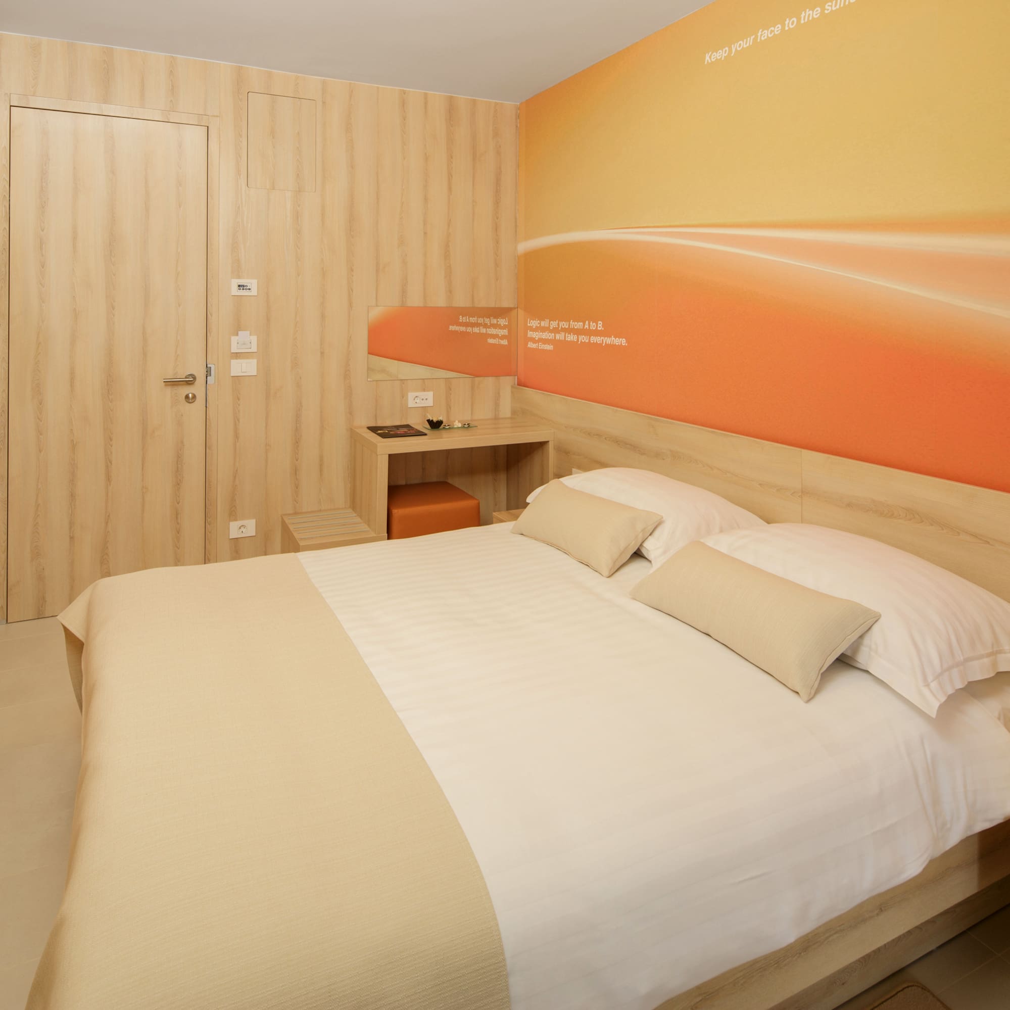 a bed with pillows and a wallpaper on the wall