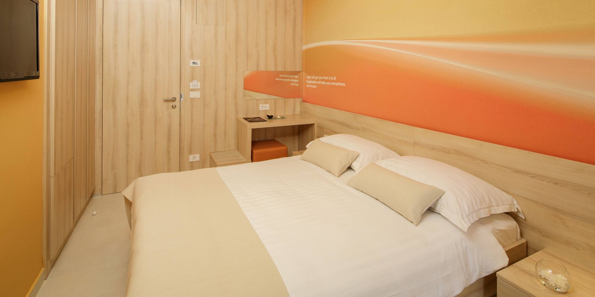 a bed with pillows and a wallpaper on the wall