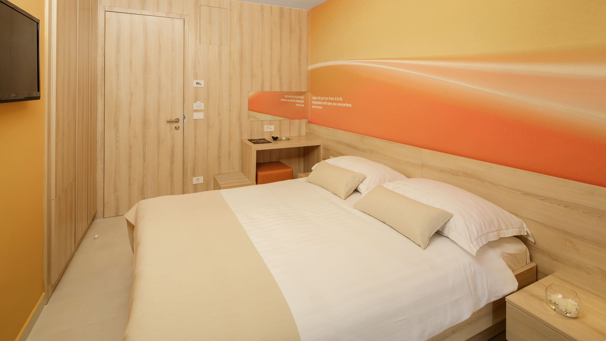 a bed with pillows and a wallpaper on the wall