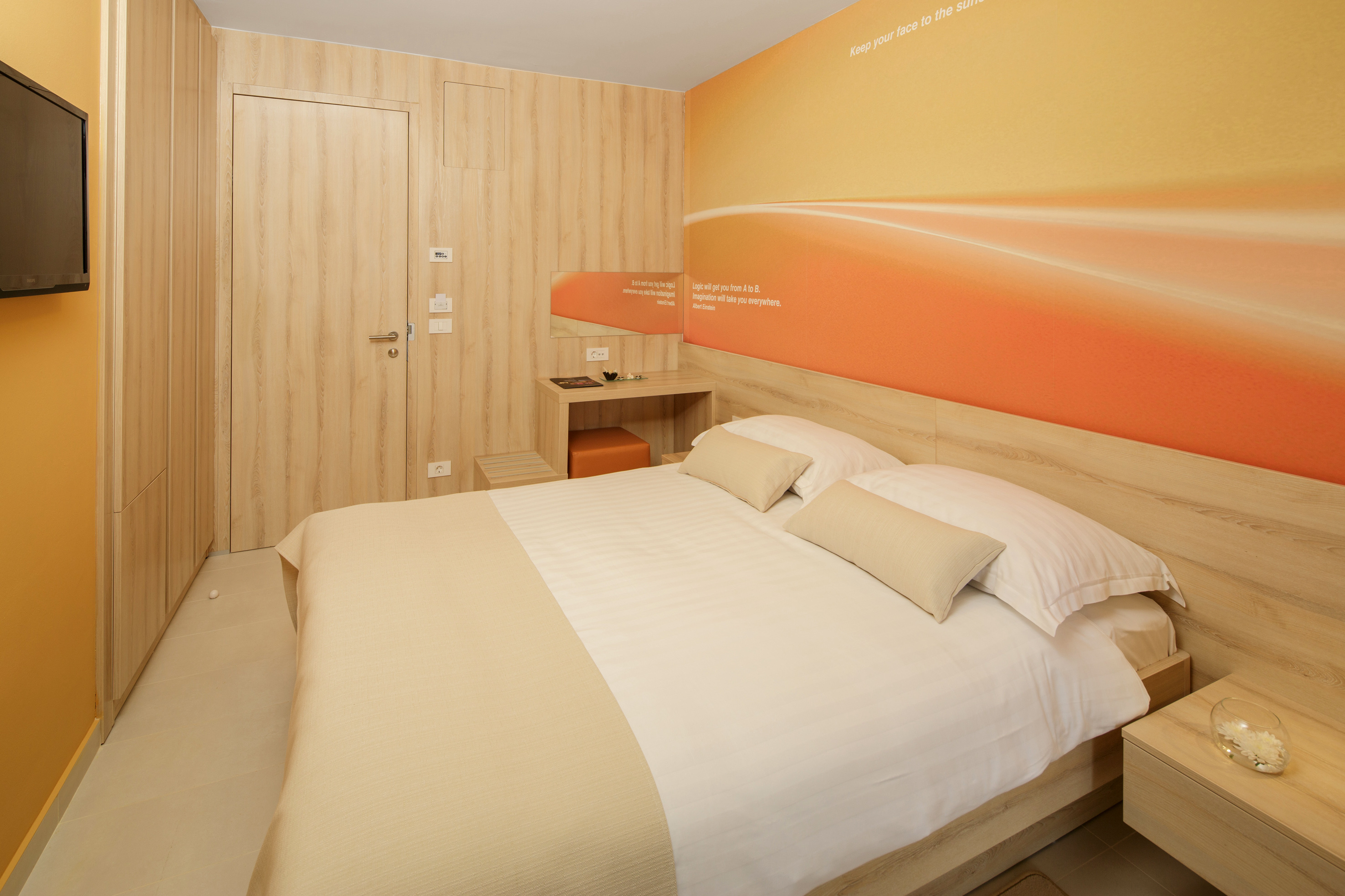 a bed with pillows and a wallpaper on the wall