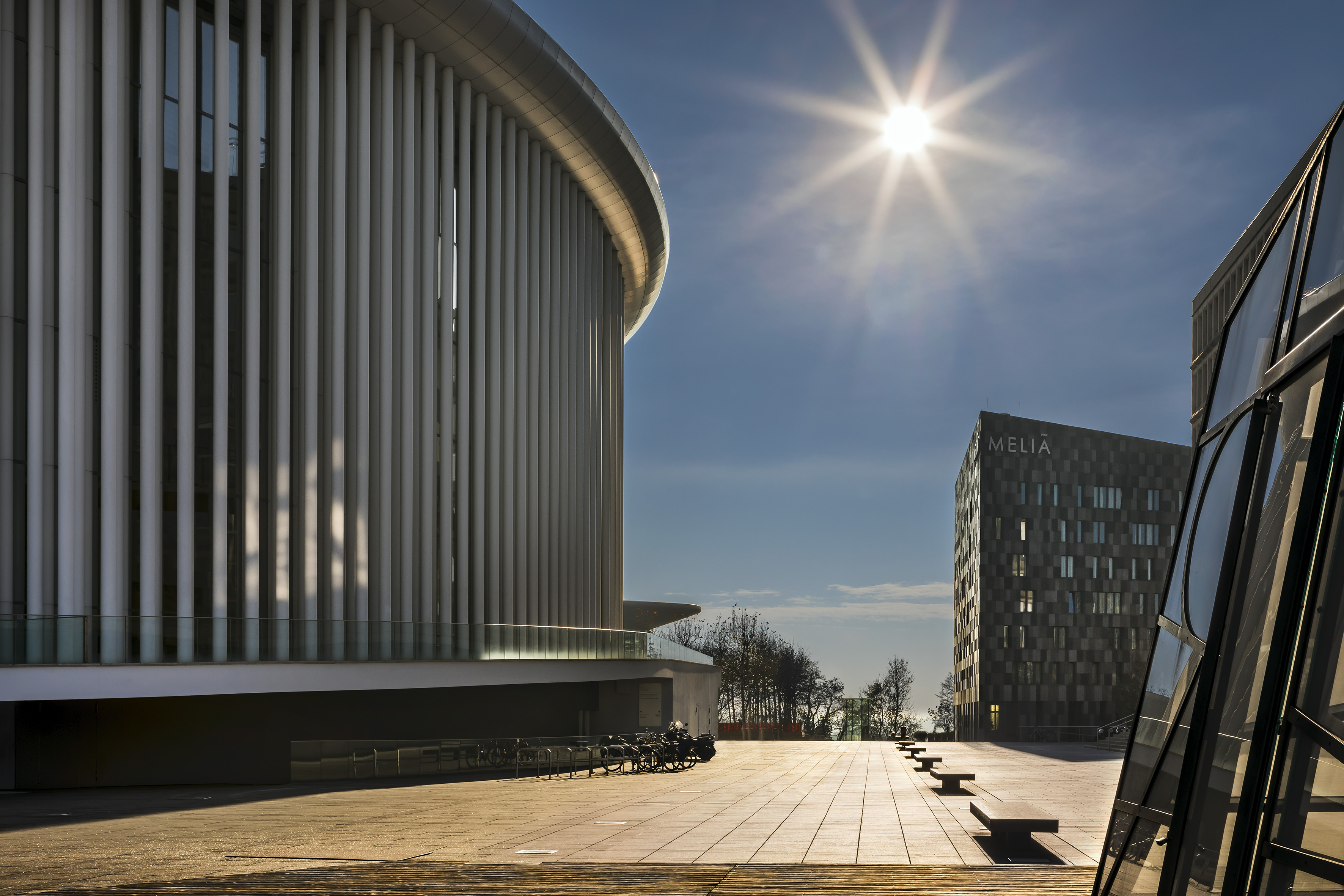 Philharmonie de Luxembourg and Melia hotel on a sunny urban plaza.