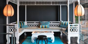 a white bench with pillows in a room