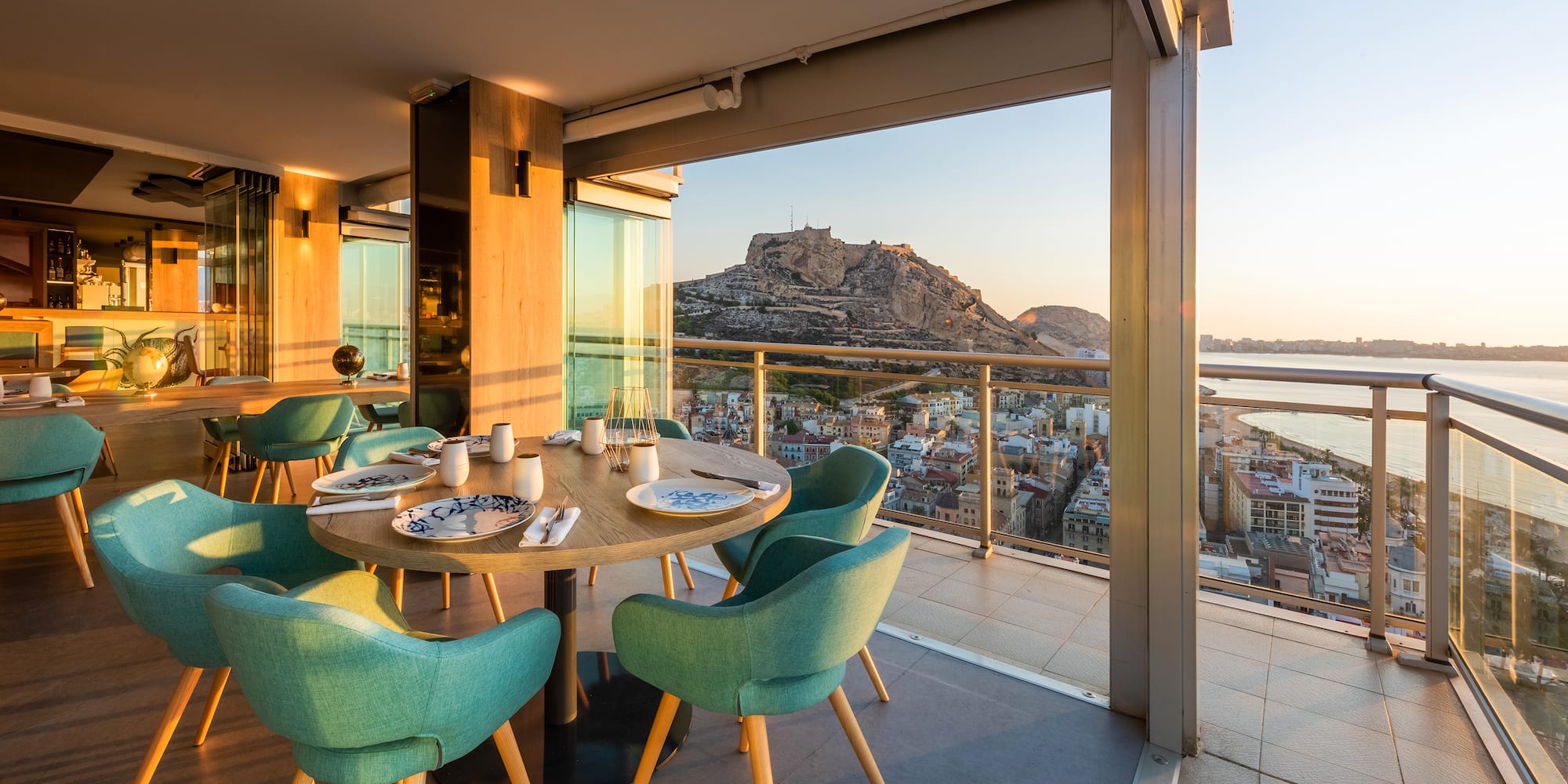 a table with blue chairs and a view of a city