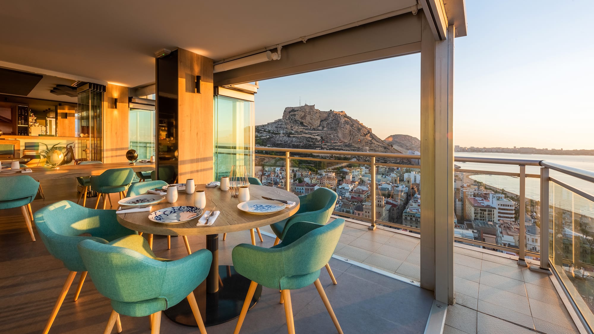 a table with blue chairs and a view of a city