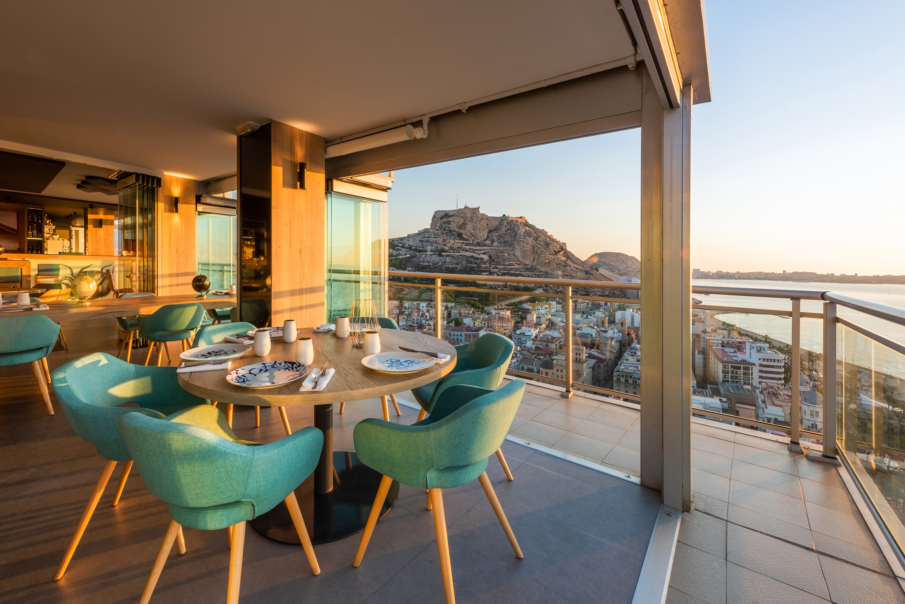 a table with blue chairs and a view of a city