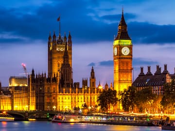 A big building with a clock tower and a bridge.