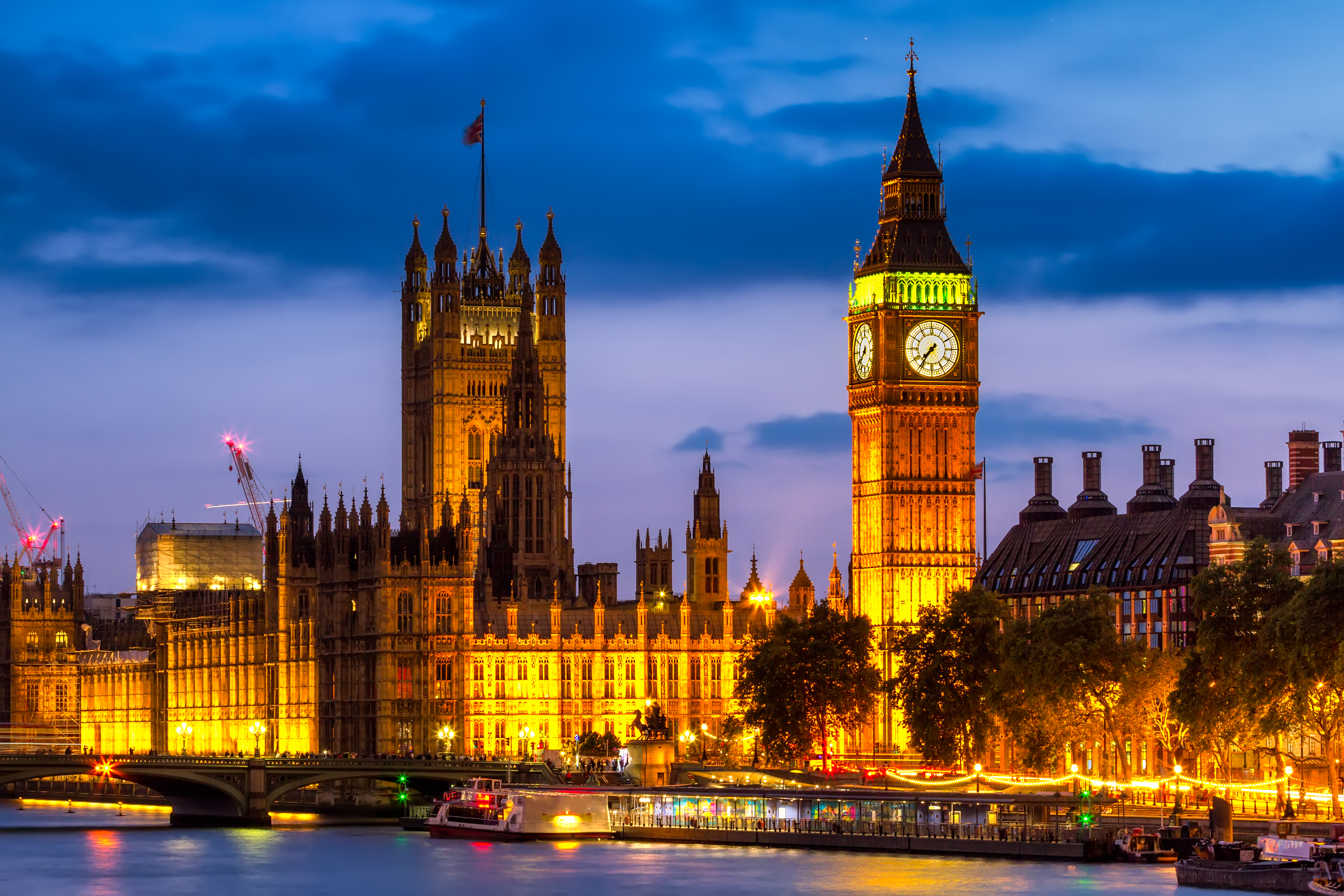 Big Ben y Parlamento de Londres iluminados al anochecer, río Támesis.