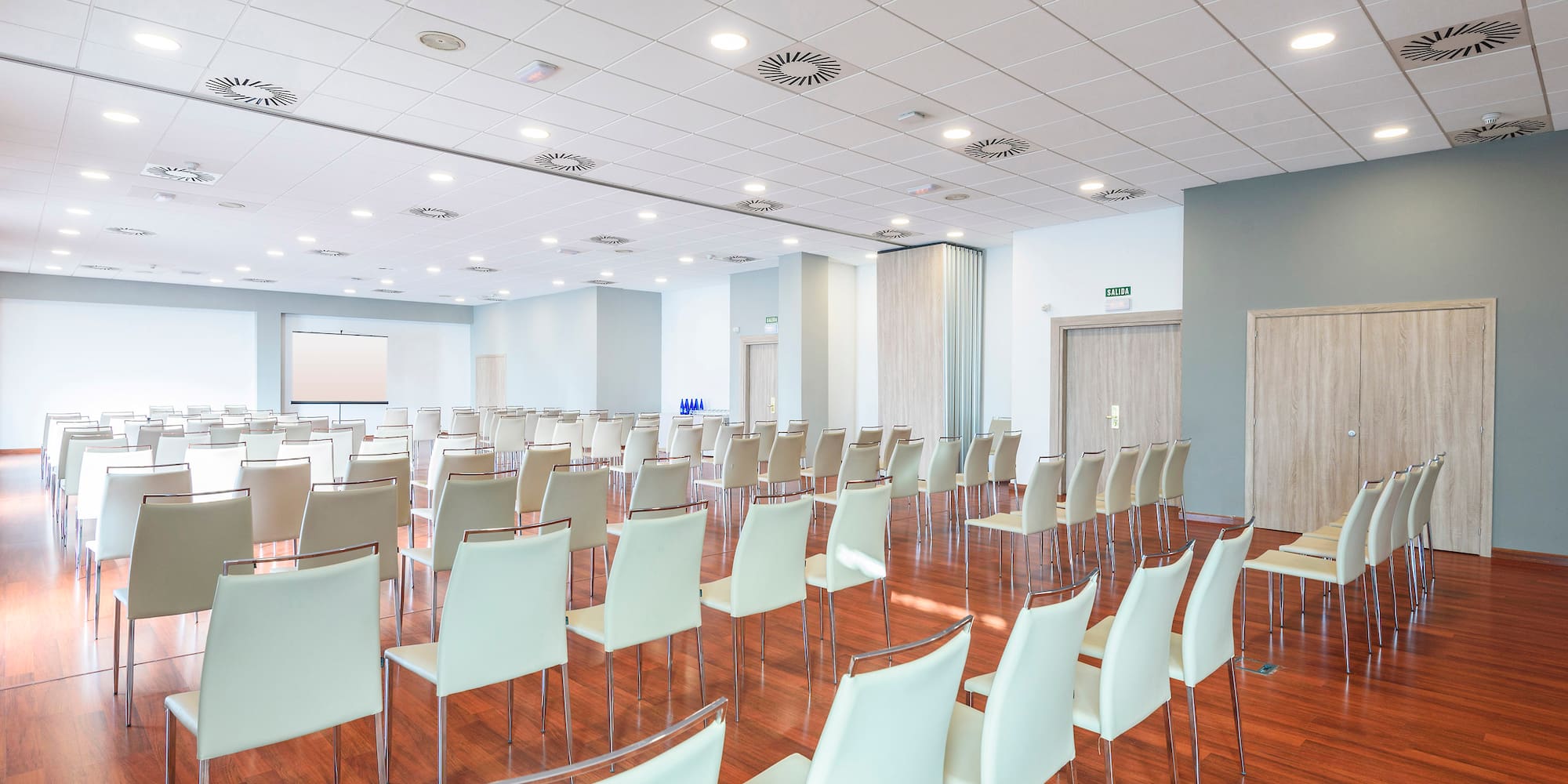 a room with white chairs and a wood floor