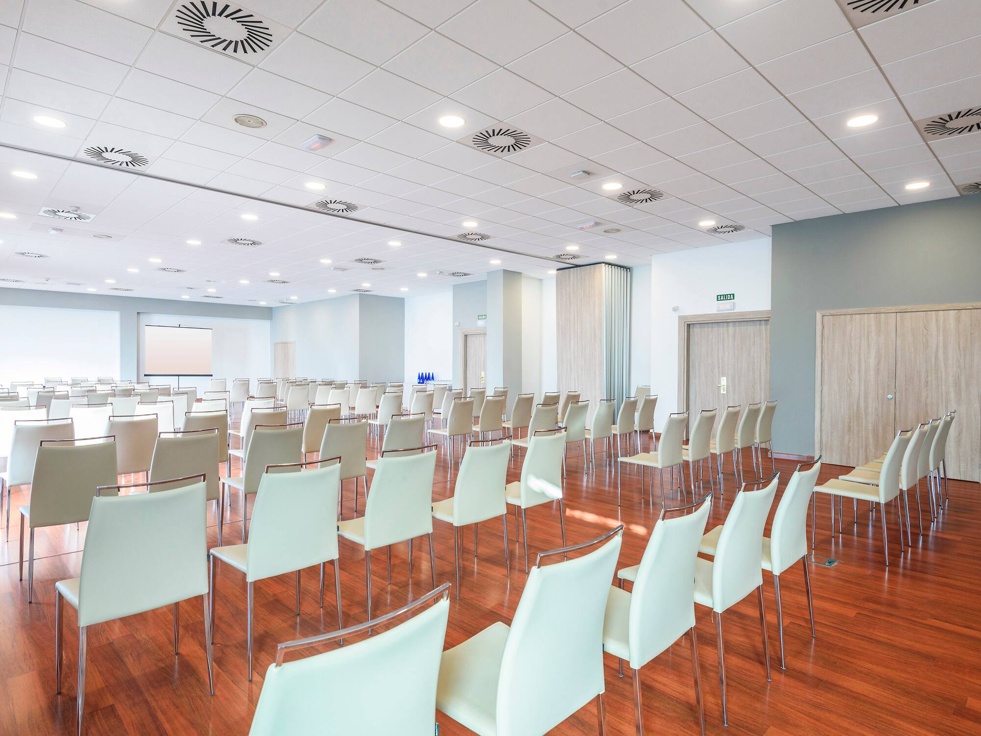 a room with white chairs and a wood floor