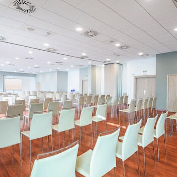 a room with white chairs and a wood floor