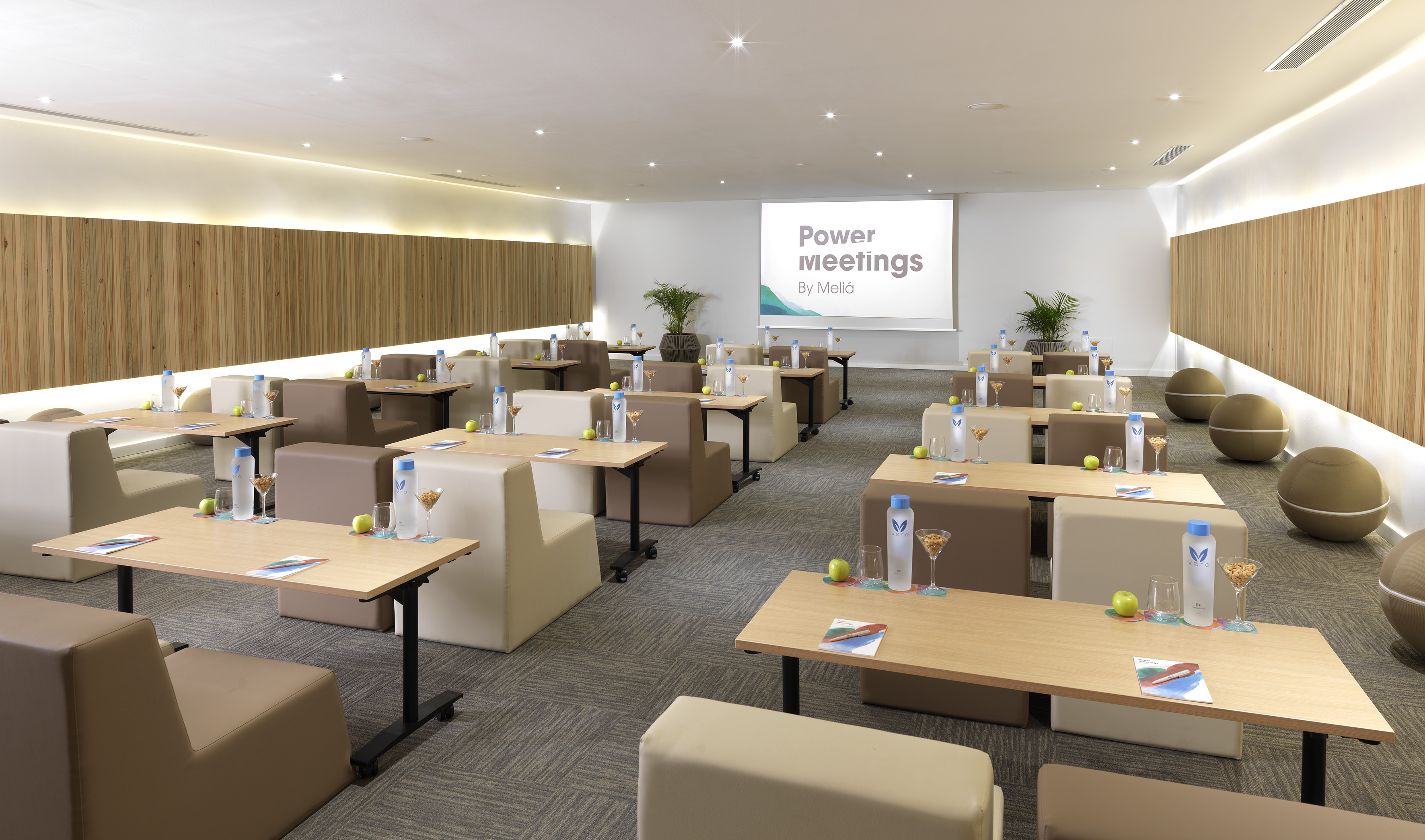 Modern Meliá conference room, flexible seating, "Power meetings" screen.