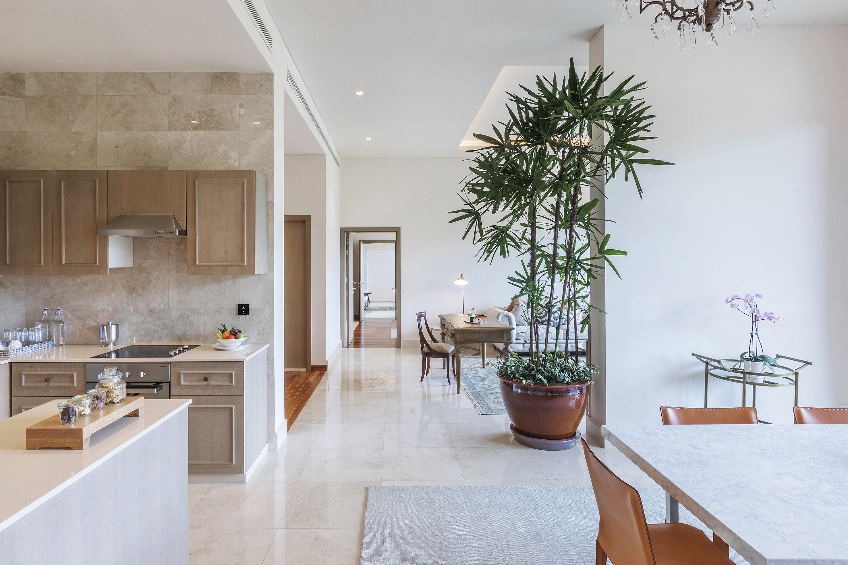 Modern open-plan kitchen, living, and dining area with marble floors.