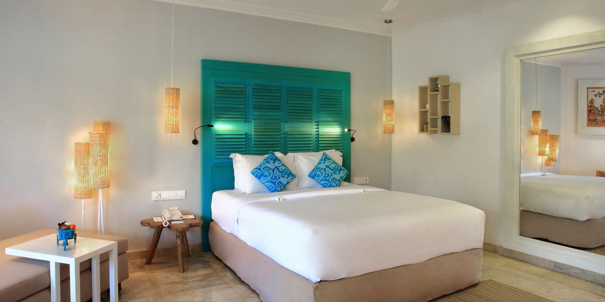 a bed with blue pillows and a fan in a room