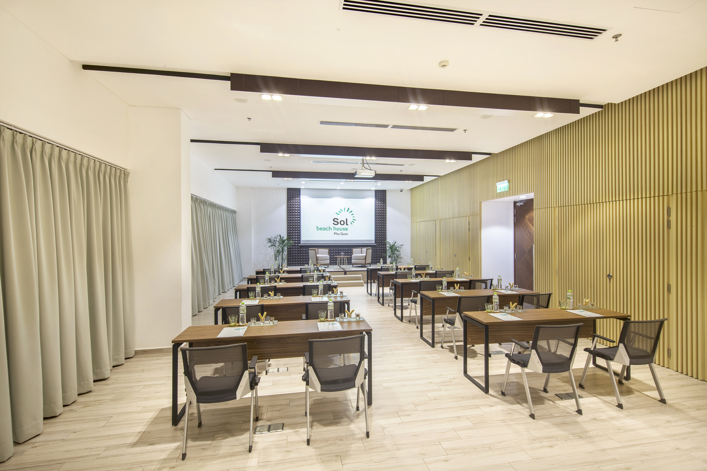 Sol Beach House Phu Quoc meeting room, tables, chairs, projector screen.