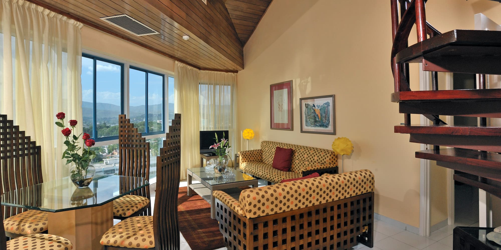 a living room with a spiral staircase and a couch and chairs