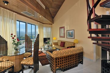 a living room with a spiral staircase and a couch and chairs