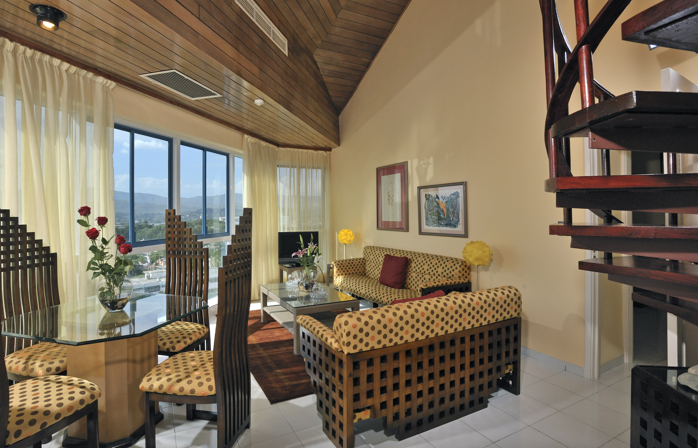 a living room with a spiral staircase and a couch and chairs