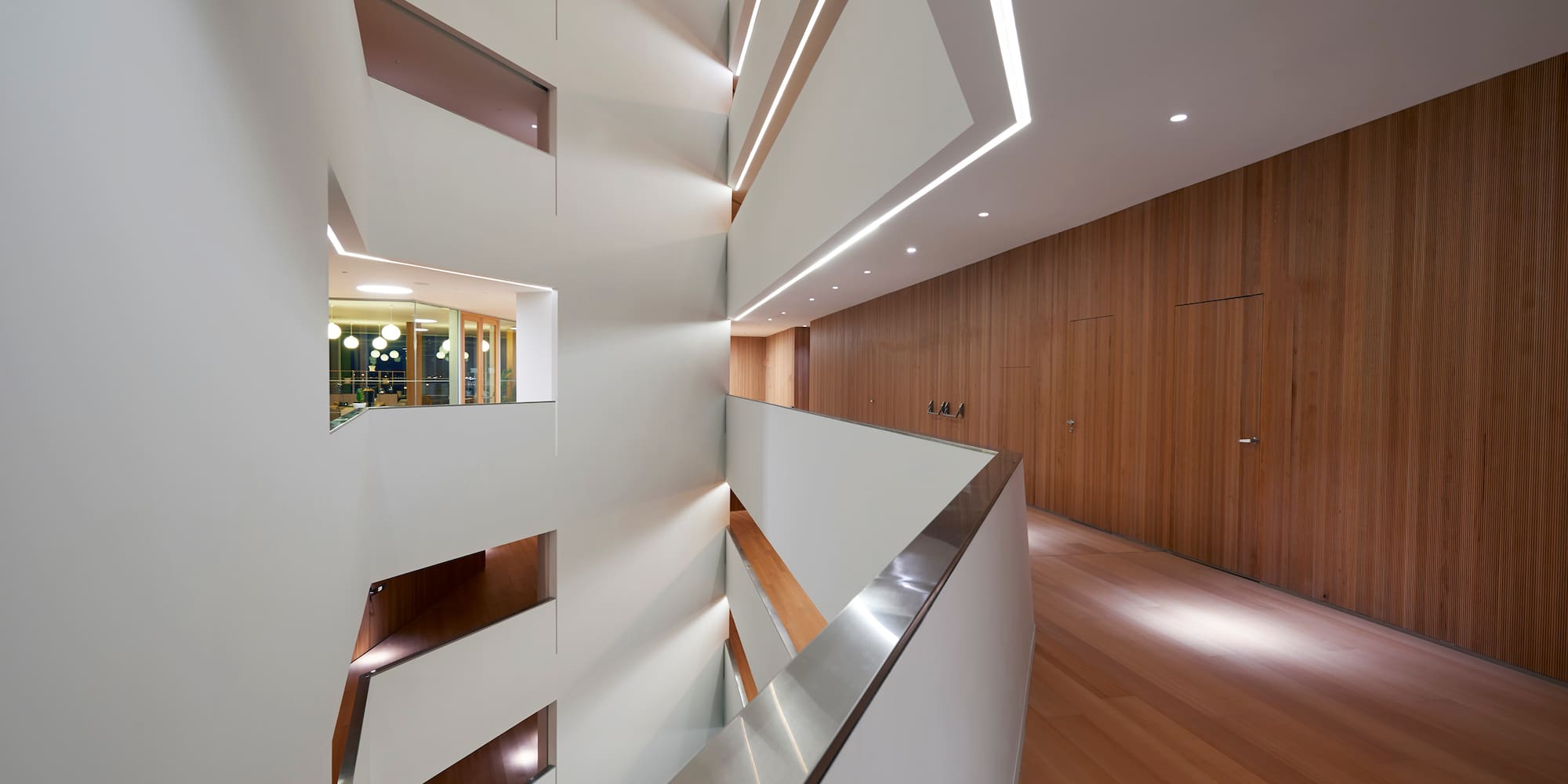 a white and wood hallway with a wood floor and a wood door