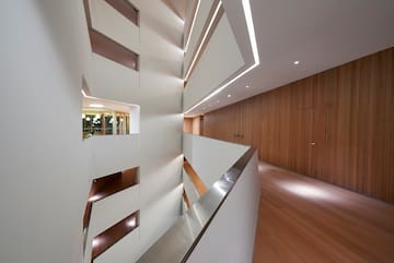 a white and wood hallway with a wood floor and a wood door