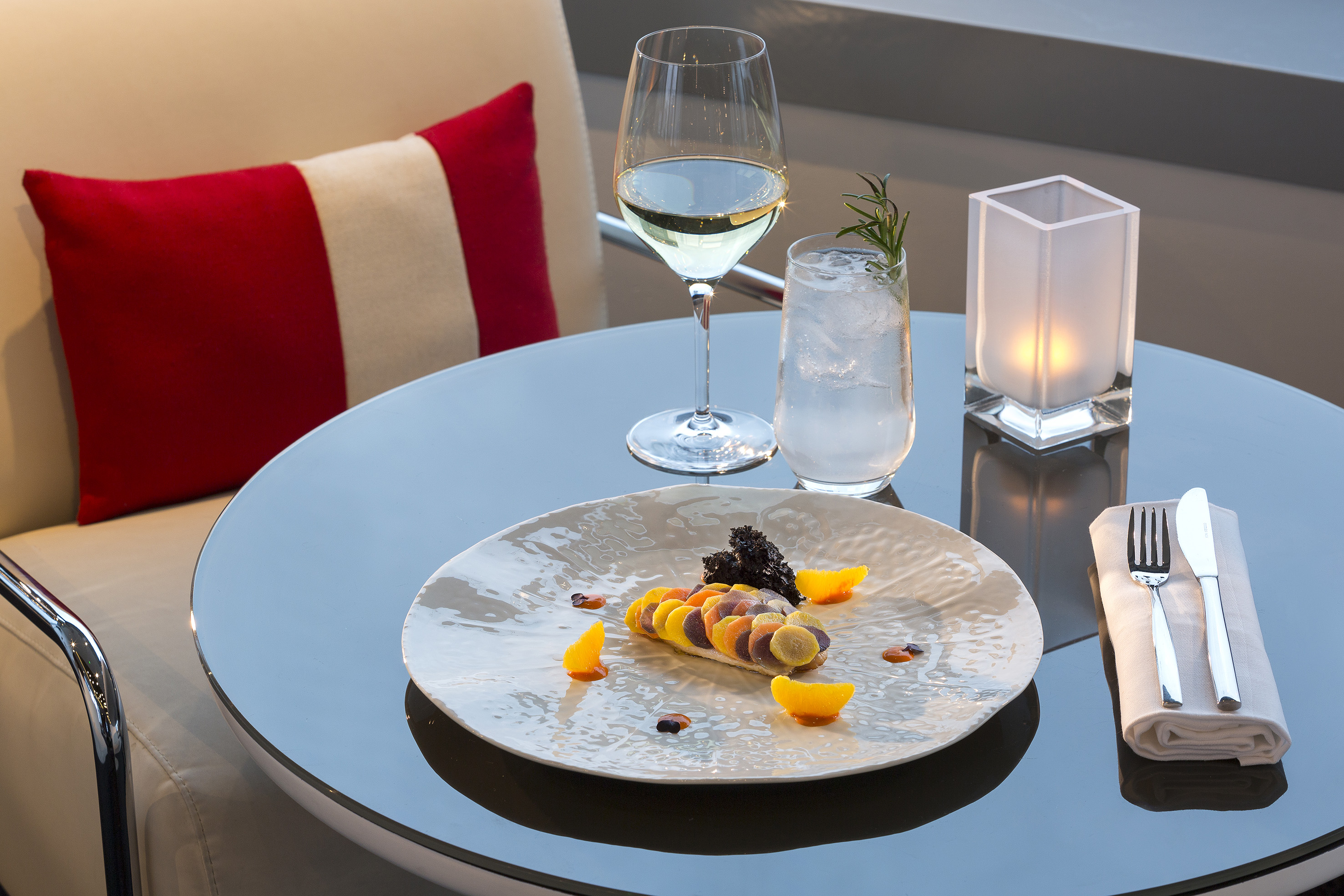Gourmet colorful vegetable dish, white wine, cocktail on elegant dining table.
