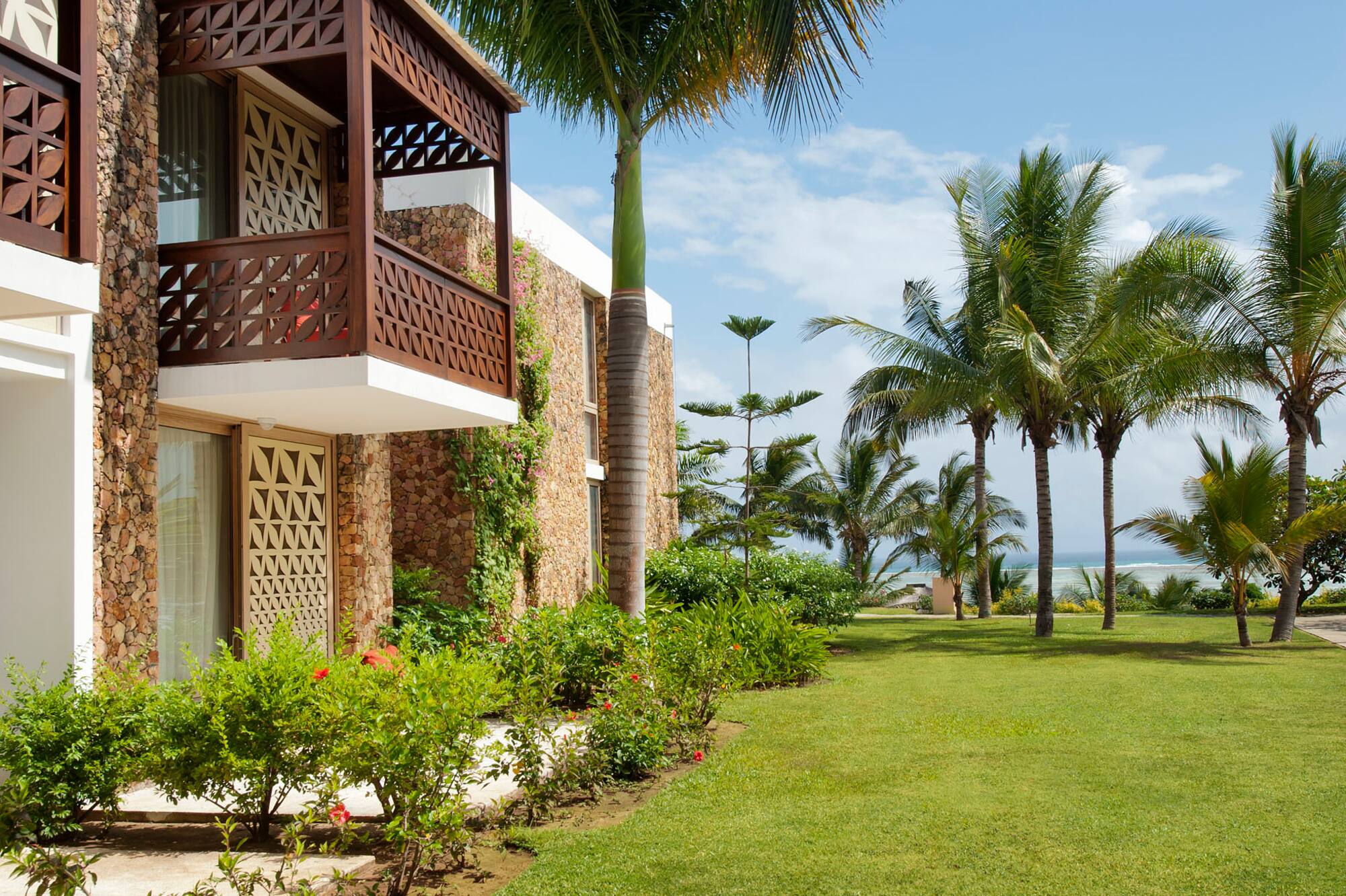 a building with a palm tree and a lawn