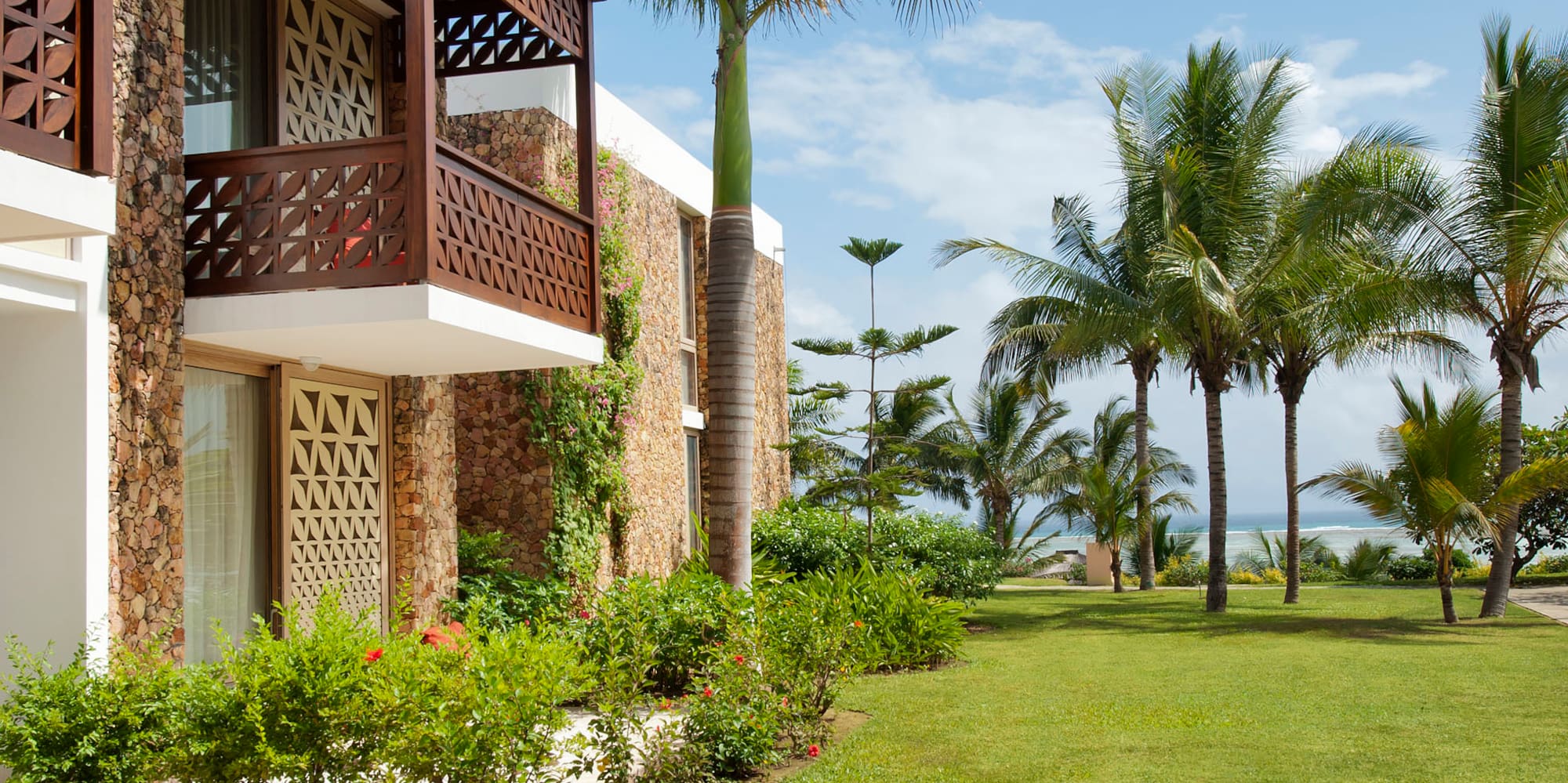 a building with a palm tree and a lawn