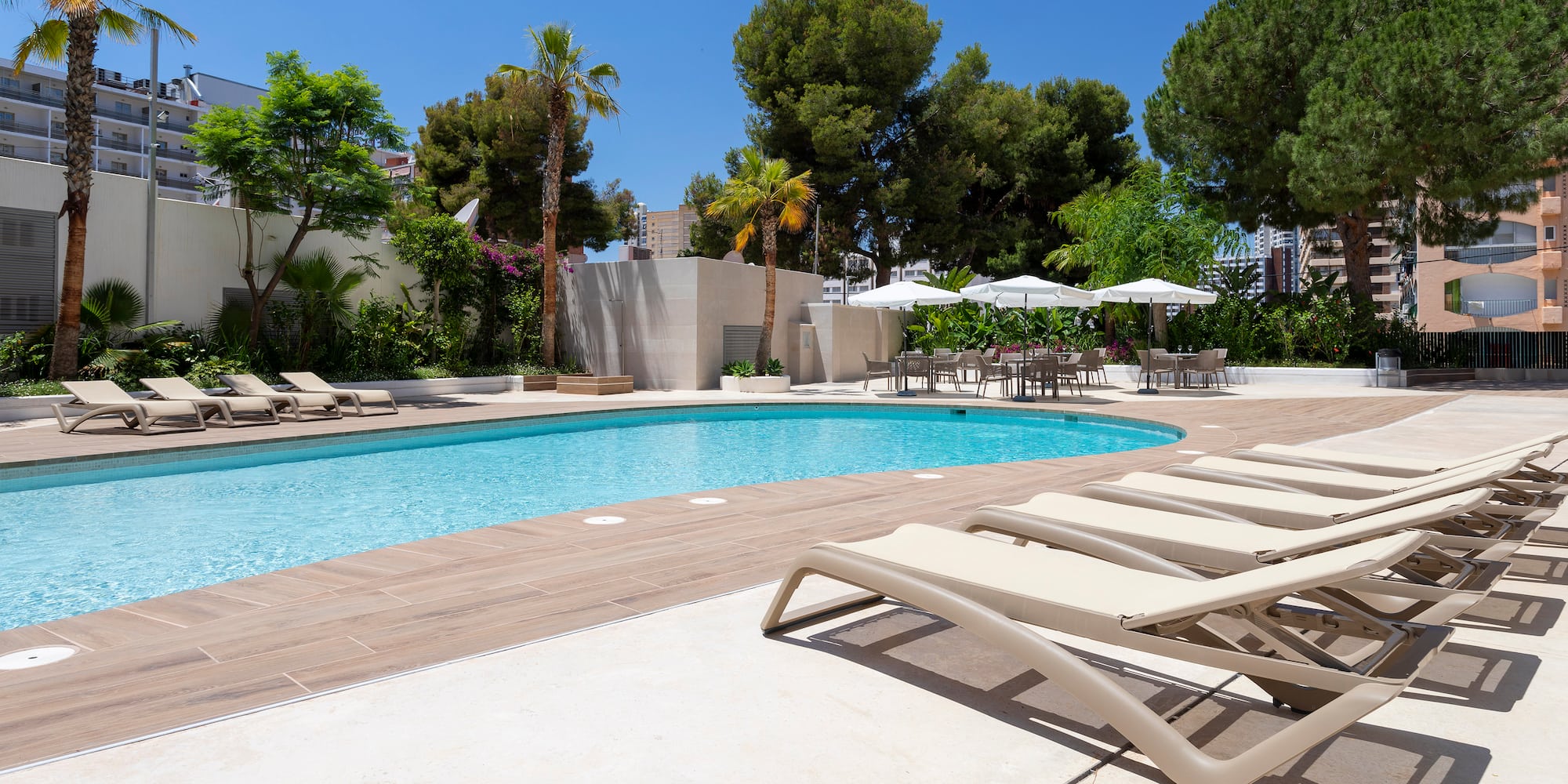 a pool with lounge chairs and umbrellas