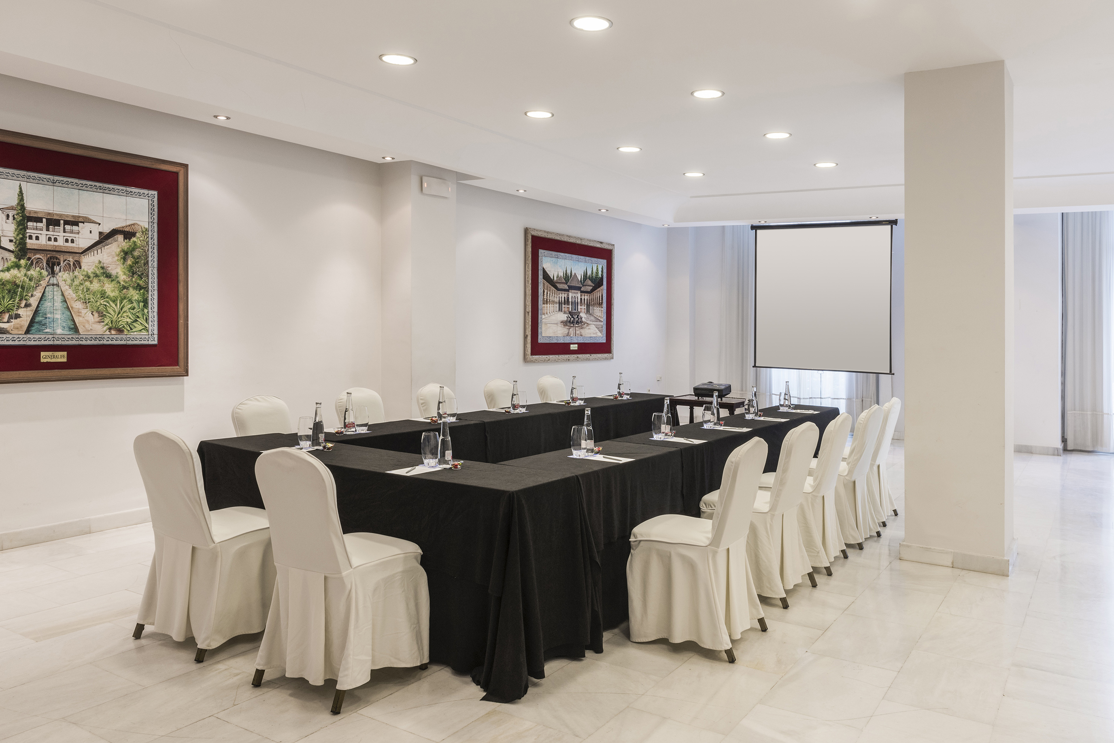 a room with black tablecloths and white chairs