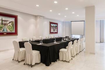 a room with black tablecloths and white chairs