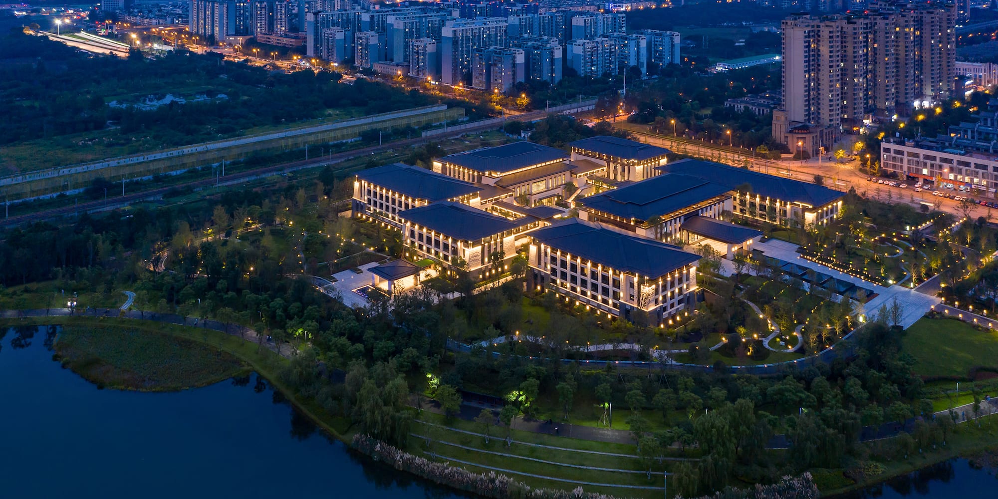 a building with lights on it and a body of water