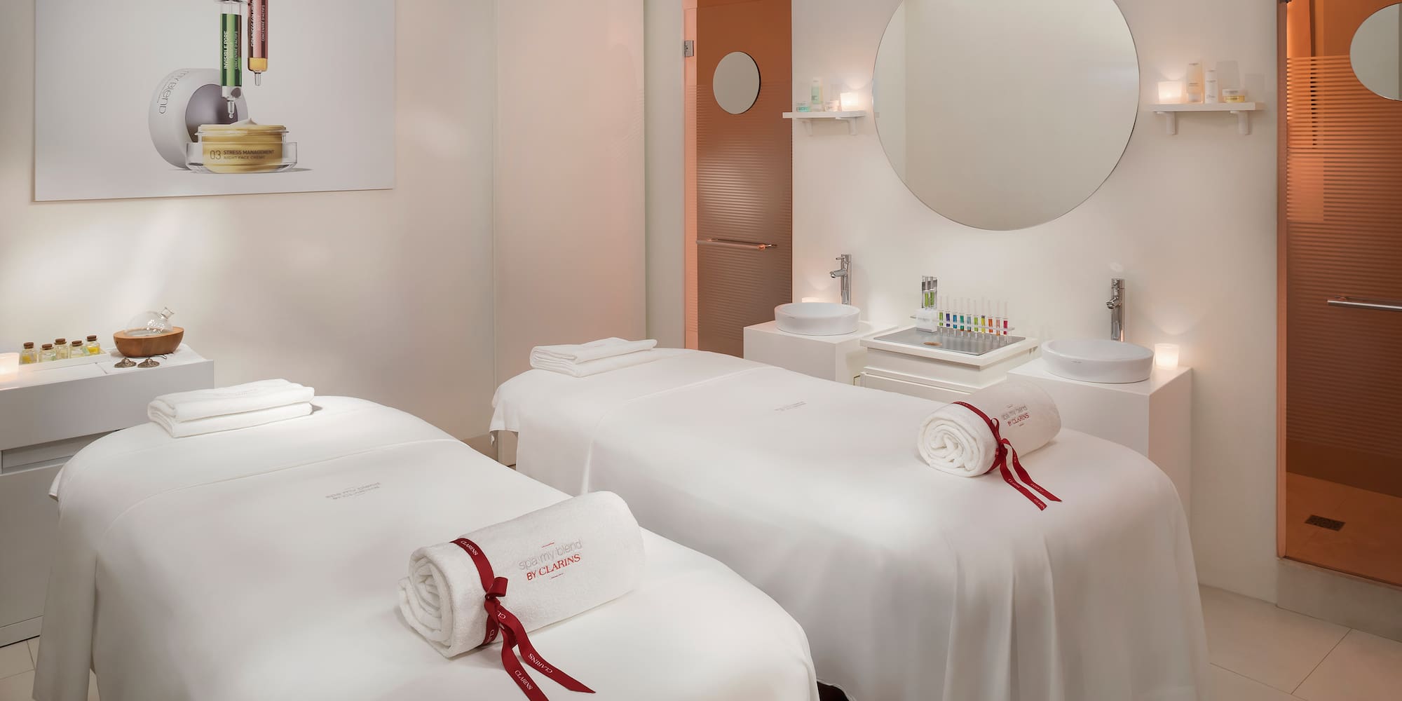 a room with white beds and mirrors