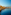 Cadiz Cathedral and waterfront city skyline, rocky breakwater, blue sea.