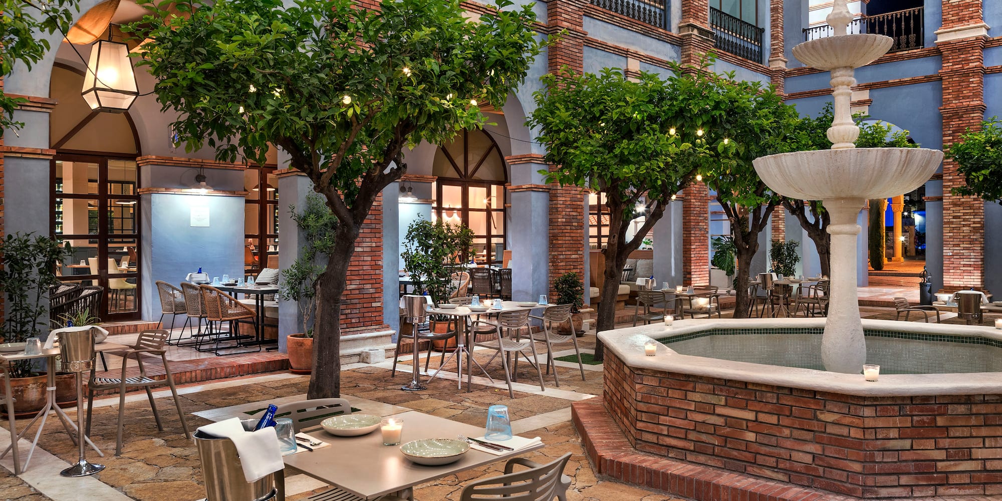 a courtyard with tables and chairs and trees