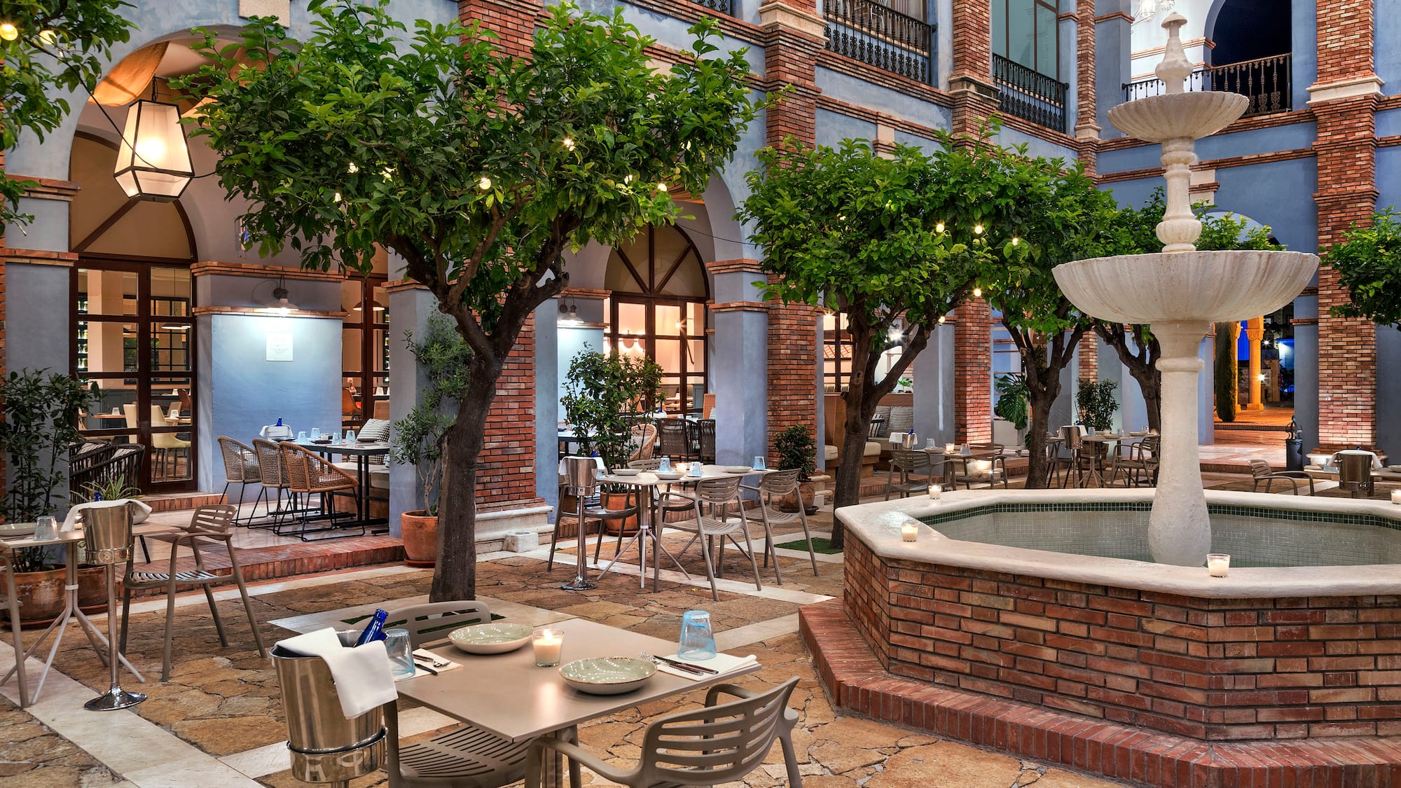 a courtyard with tables and chairs and trees