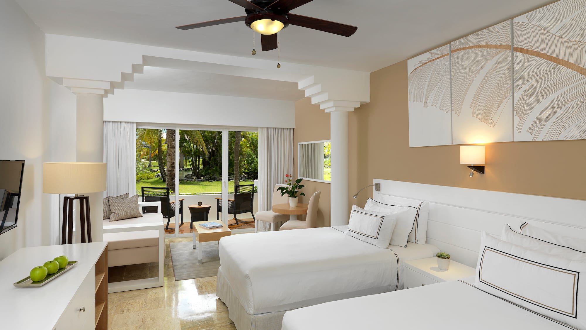 a room with two beds and a ceiling fan