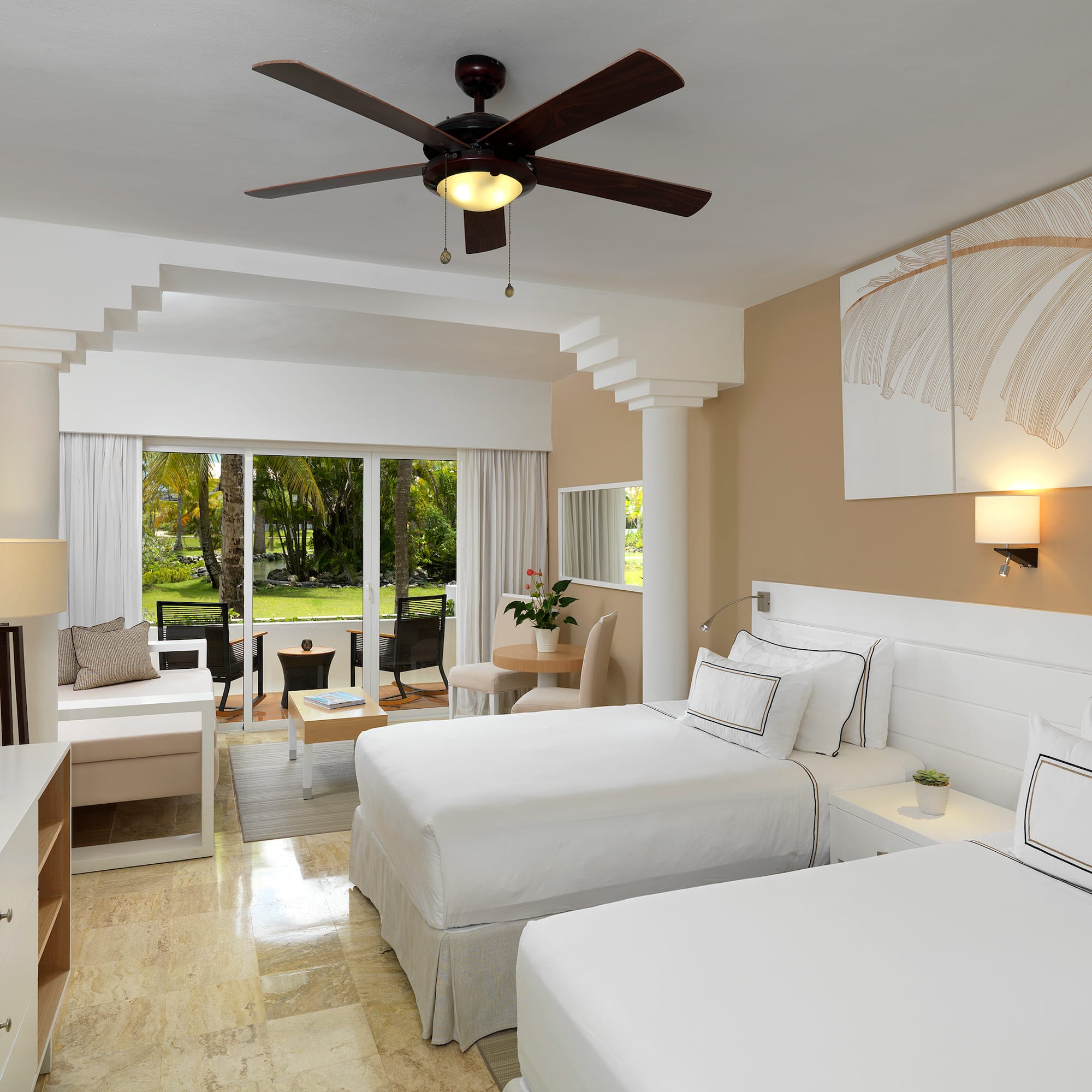 a room with two beds and a ceiling fan