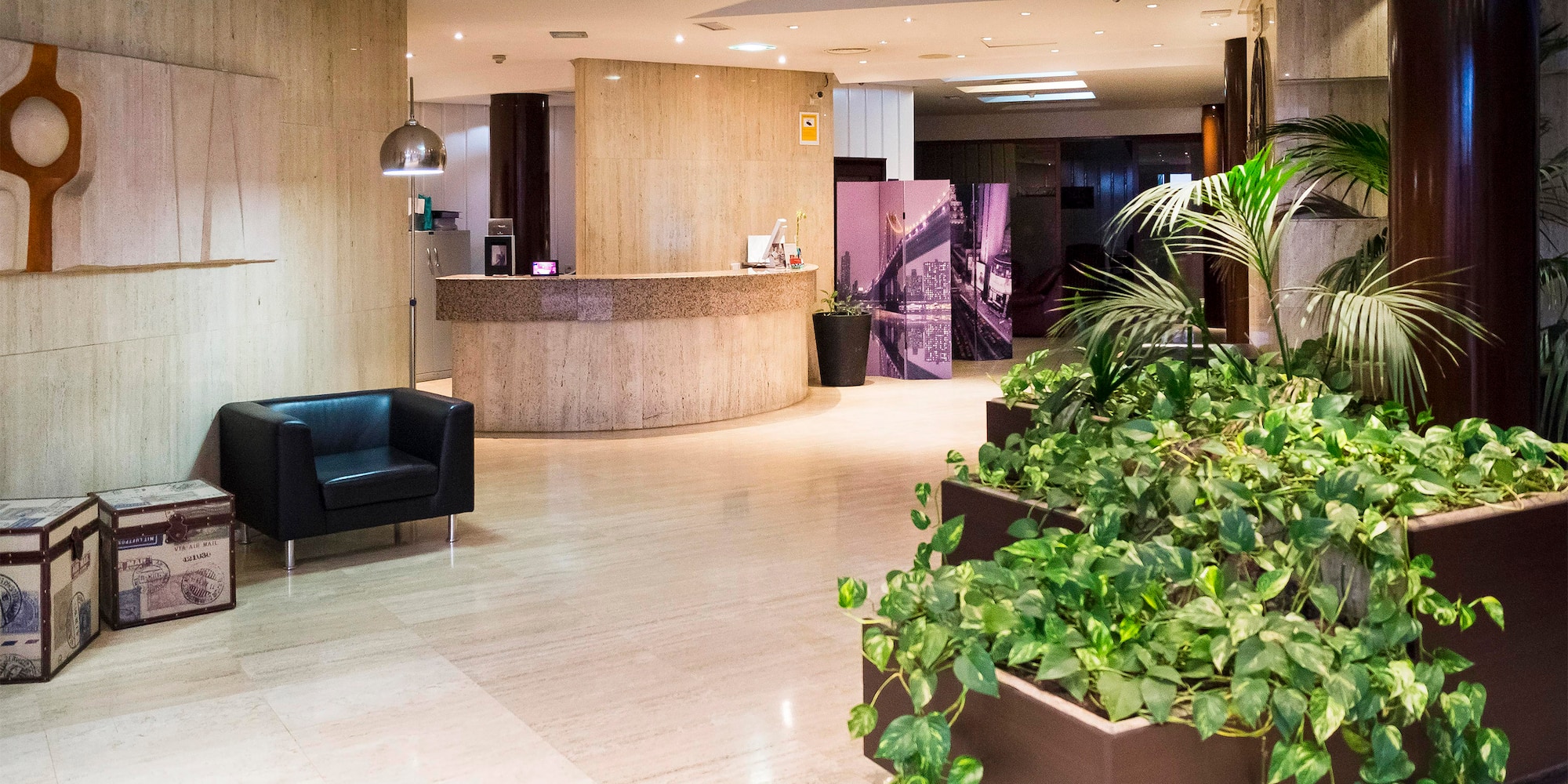 a lobby with plants and a chair