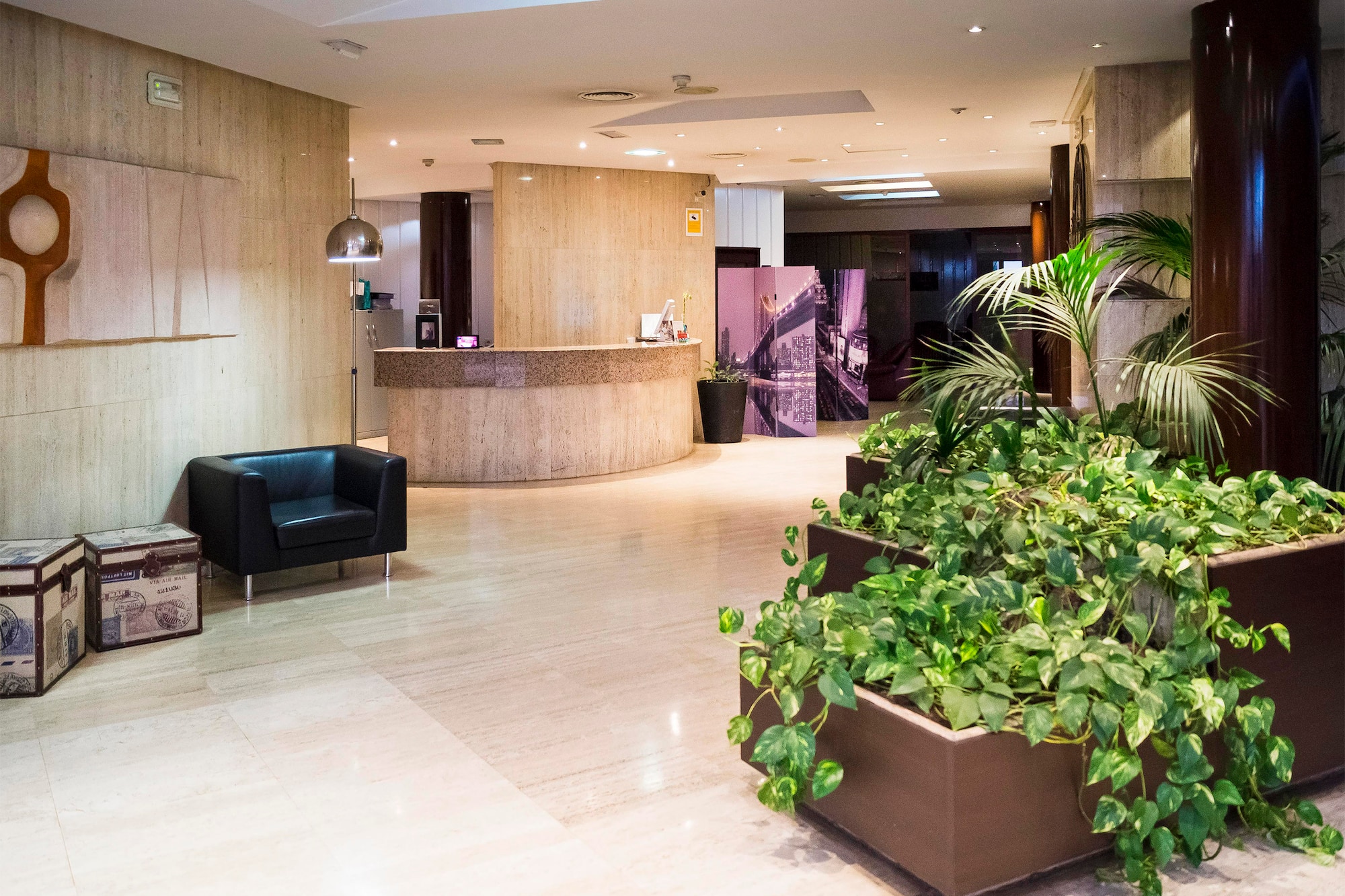 a lobby with plants and a chair