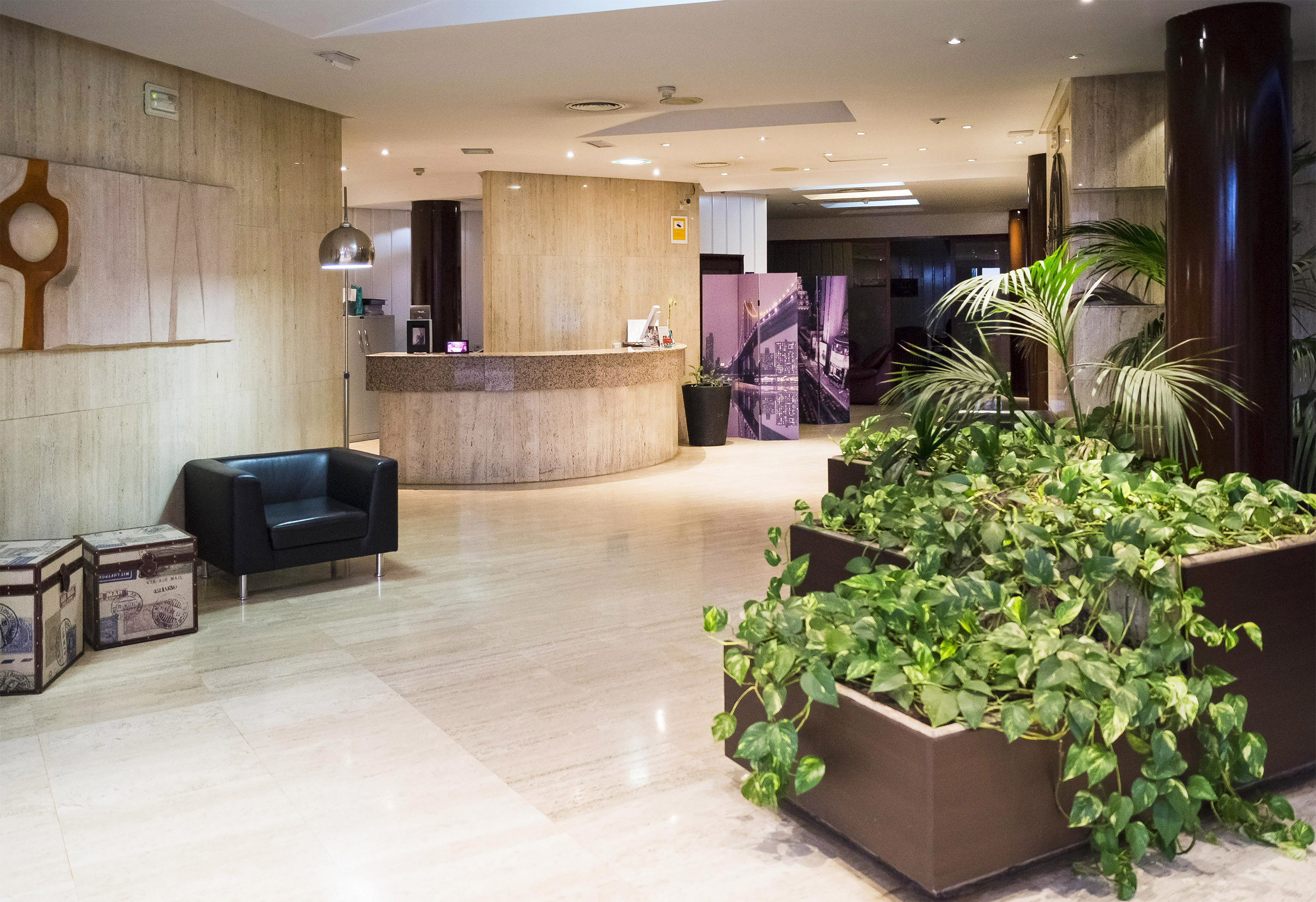 a lobby with plants and a chair