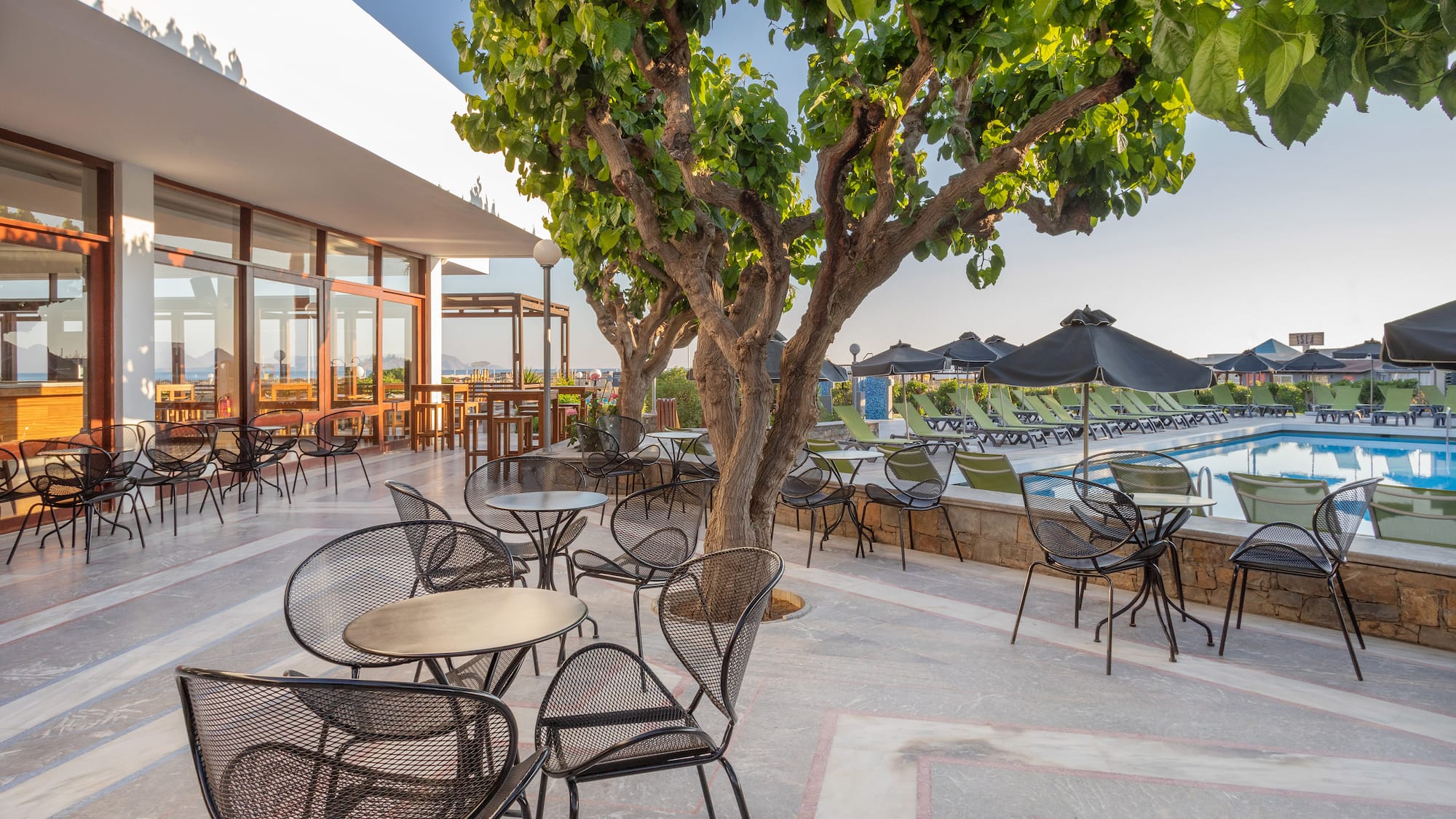 a patio with chairs and tables and a pool