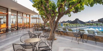 a patio with chairs and tables and a pool