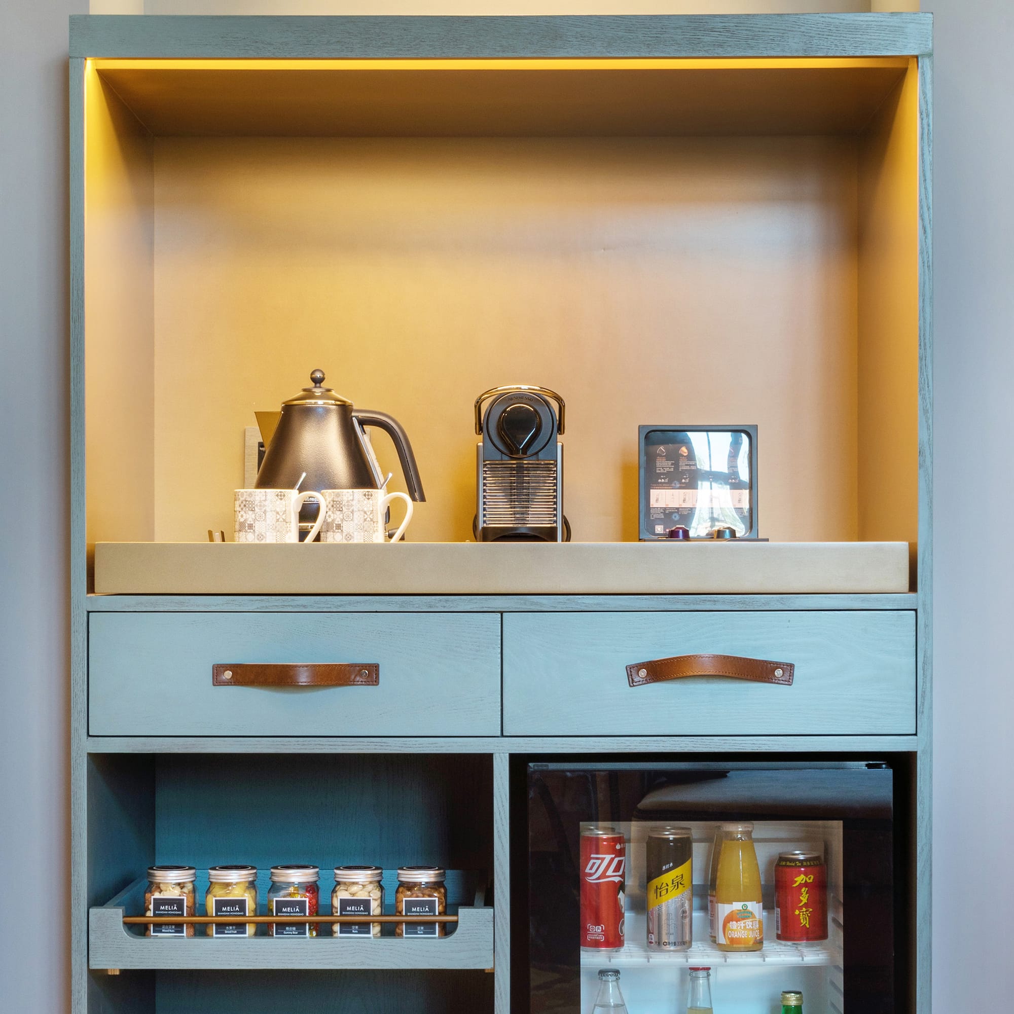 a shelf with a small refrigerator and a teapot on top