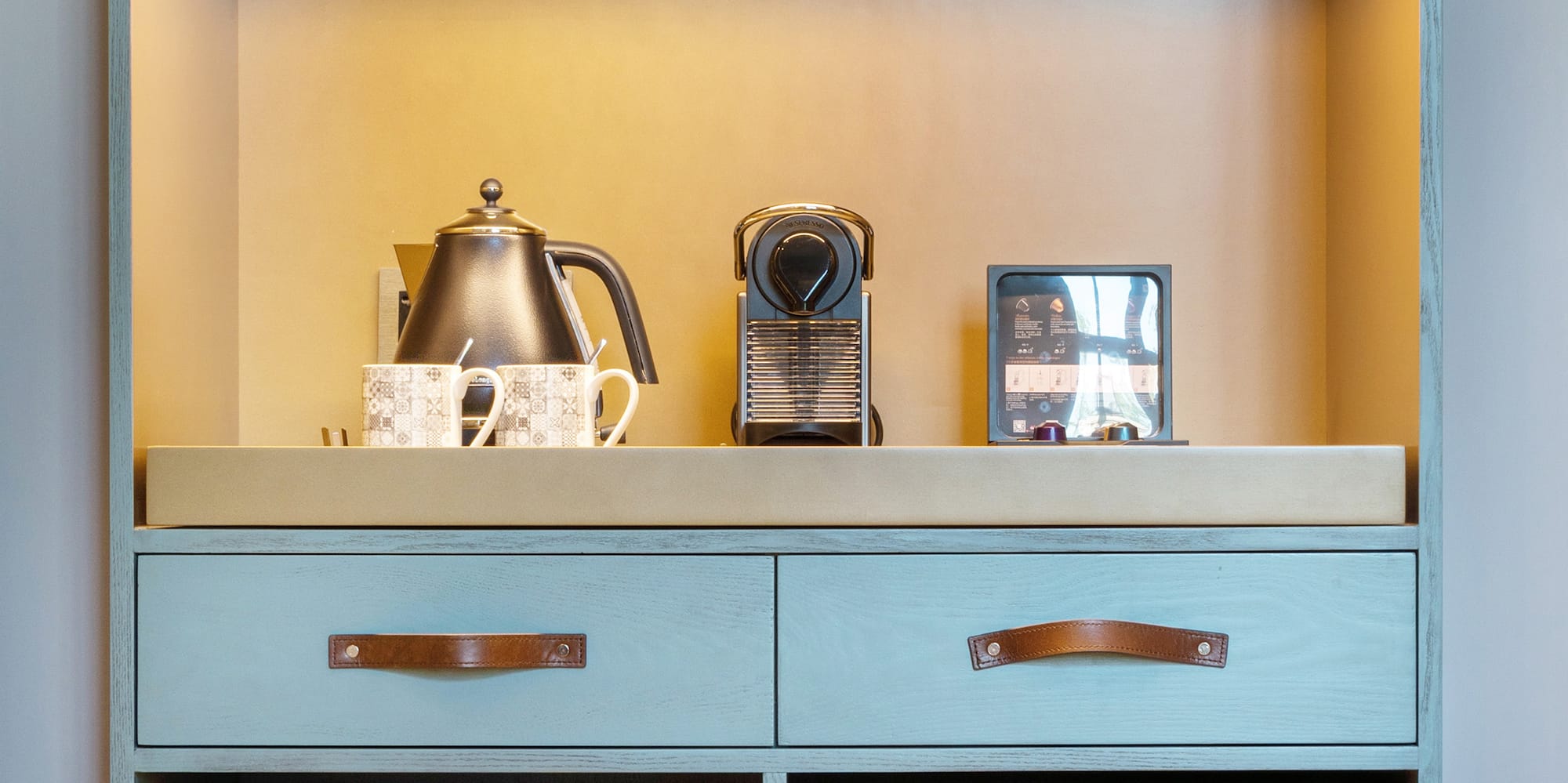 a shelf with a small refrigerator and a teapot on top