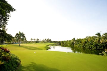 a golf course with a river and trees