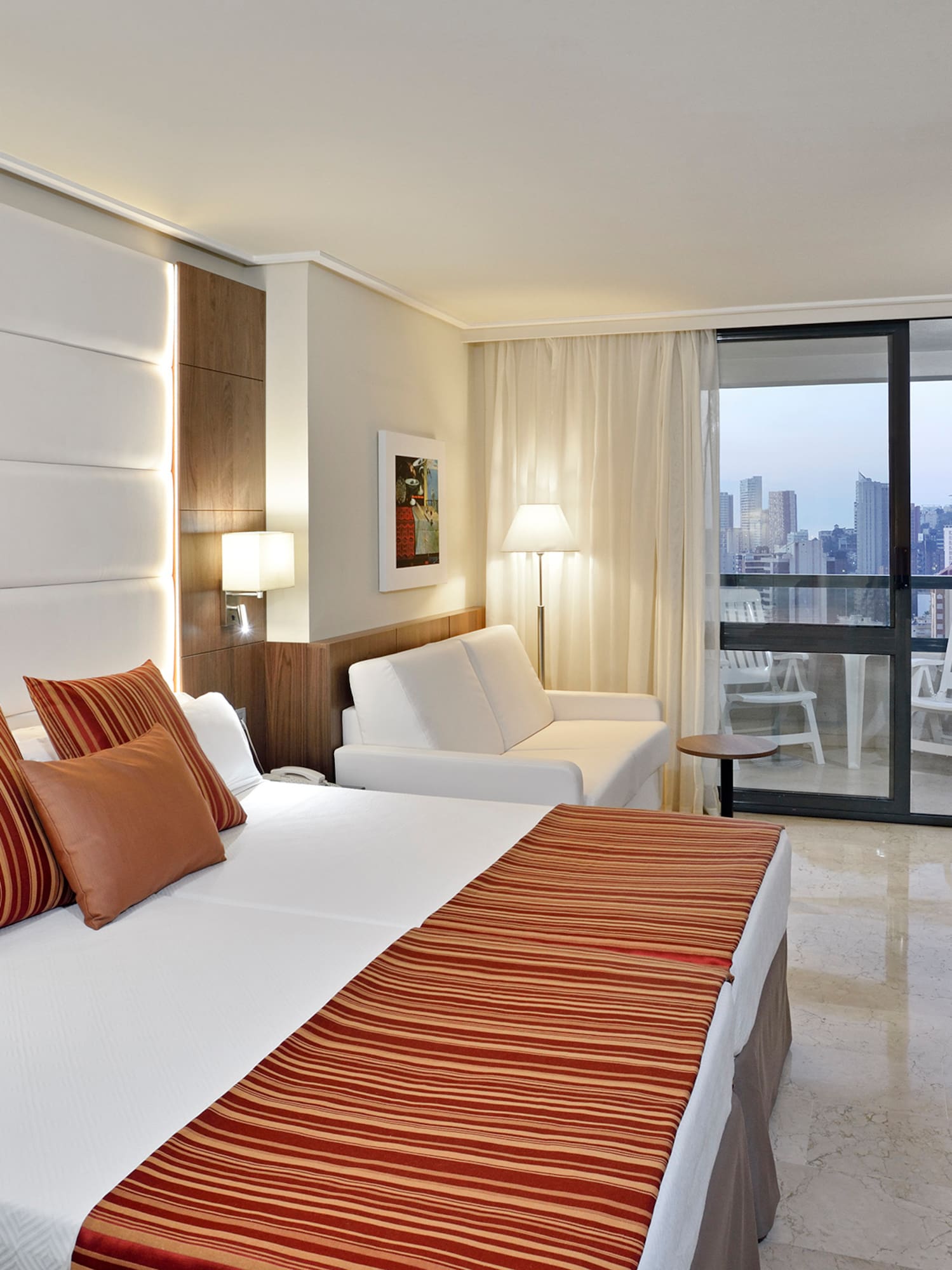 a hotel room with a bed and chairs