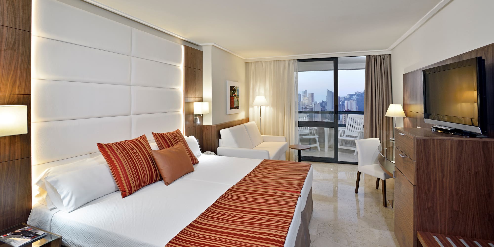 a hotel room with a bed and chairs