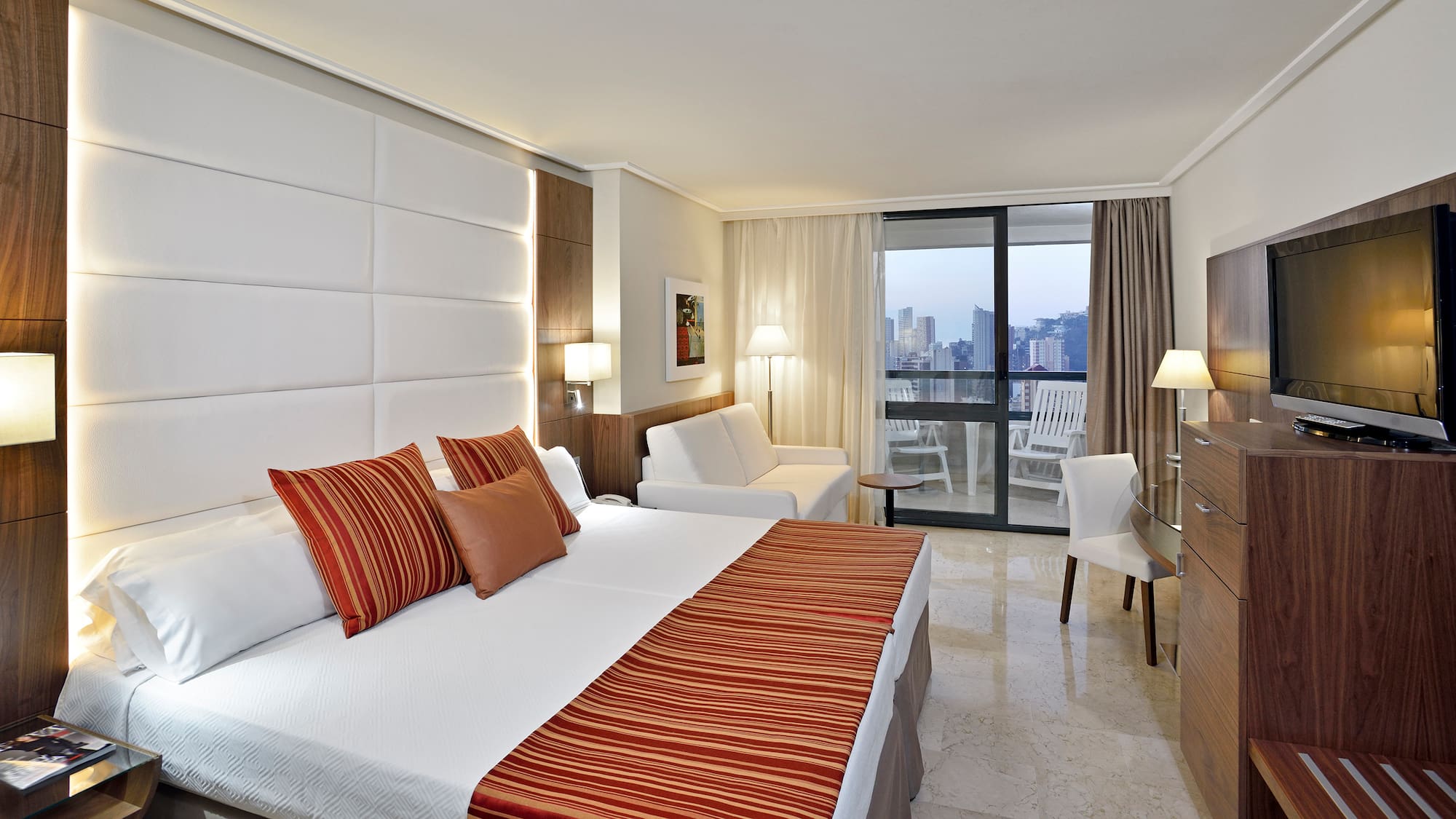 a hotel room with a bed and chairs