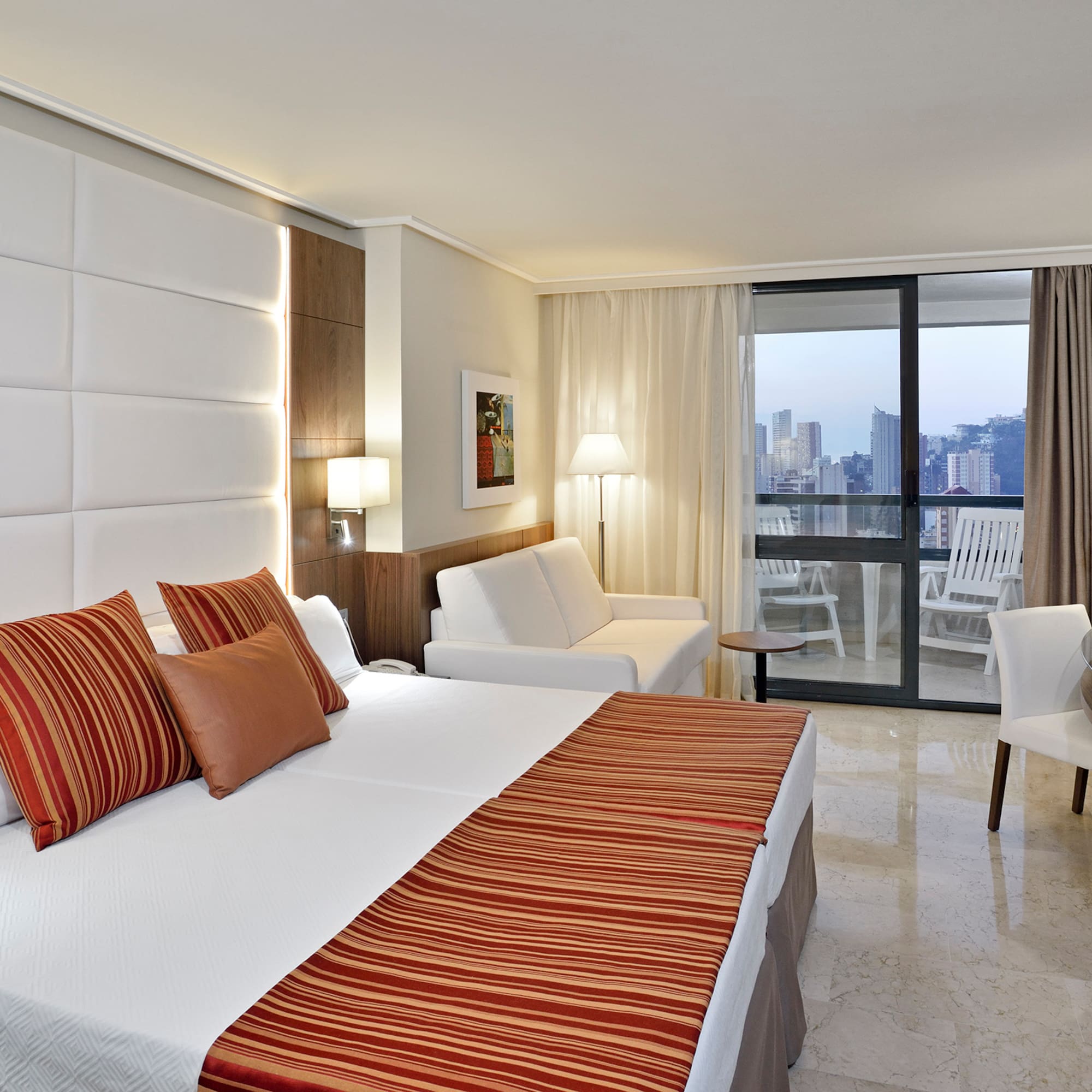 a hotel room with a bed and chairs