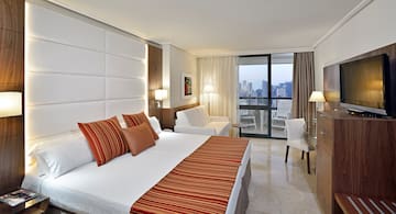 a hotel room with a bed and chairs